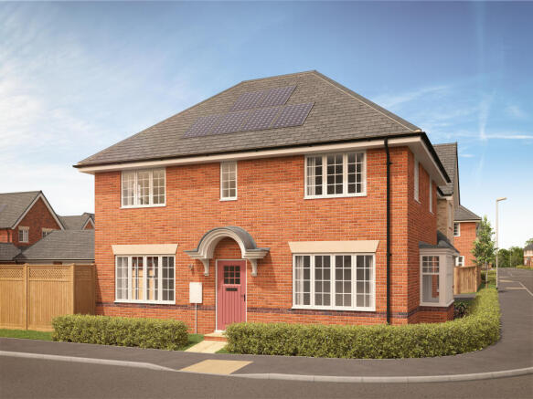 A brick house with a pink door and manicured hedges in the foreground sits under a bright blue sky w