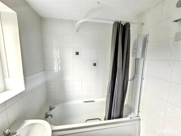 Bright bathroom with a full bathtub and shower...