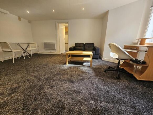 A spacious, well-lit living room featuring a co...