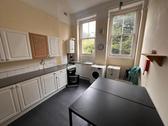 Bright kitchen with high sash windows overlooki...