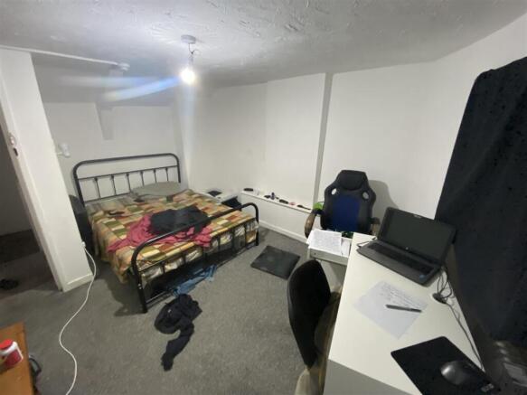 Spacious bedroom with double bed and desk area...