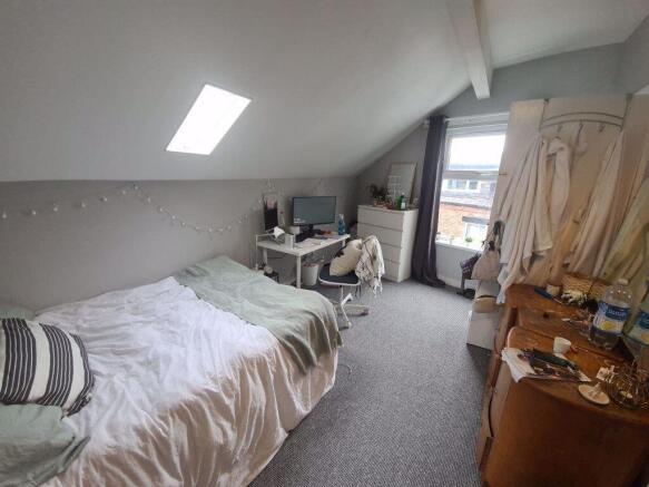 A cozy bedroom featuring a single bed with a st...