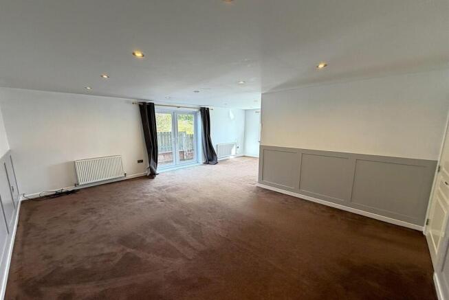 Expansive modern lounge with bright garden acce...