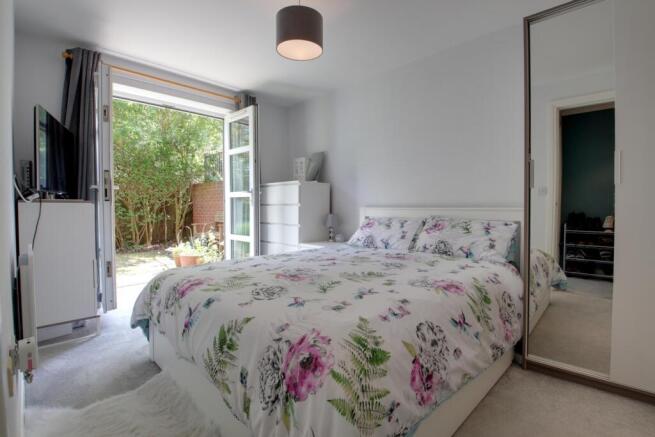 Bedroom with double doors to the seating and garde