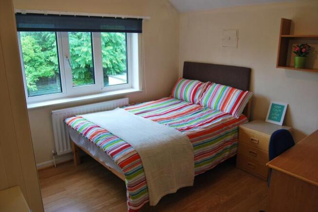 Bright bedroom with large window and double bed...