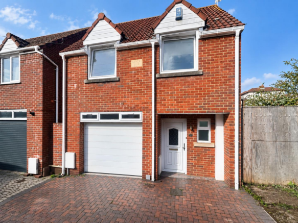 Sunlit Red-Brick House and Driveway.png