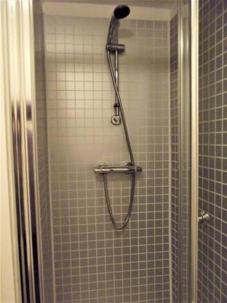 Modern tiled shower cubicle with a chrome therm...