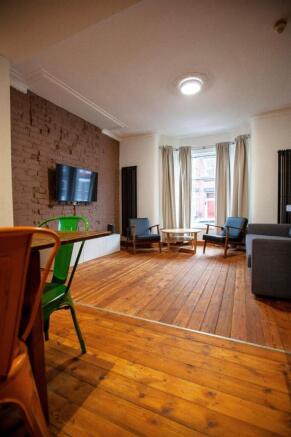 Spacious living area with warm wood flooring...