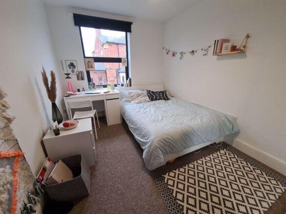 Bright and cozy single bedroom featuring a comf...