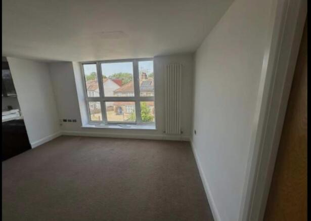 Bright, unfurnished living room with a wide win...