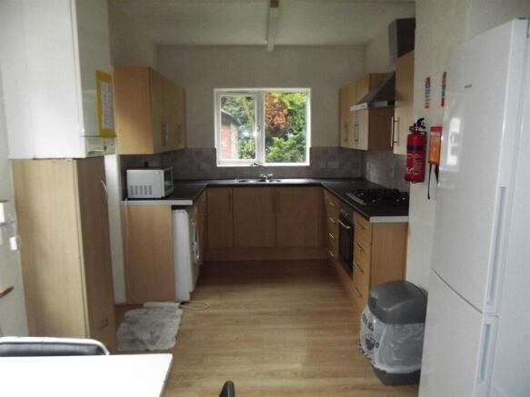 Bright galley-style kitchen with light wood cab...