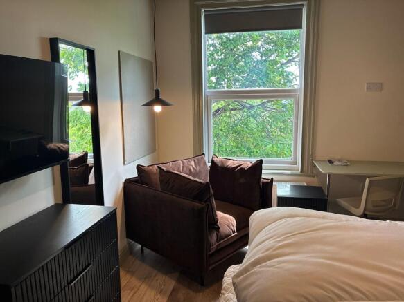 Bright bedroom with cozy chair and desk area...