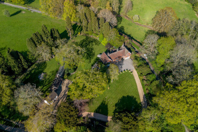 Aerial view of 1.2 acre plot including the four outbuildings and direct access onto the Ashdown Forest