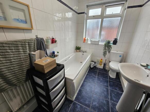 A bright and clean bathroom with a bathtub, toi...
