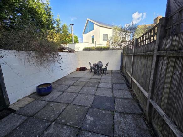 Private paved garden with seating area...