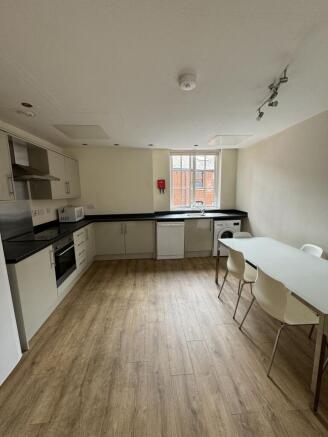 Bright modern kitchen with integrated oven, dis...