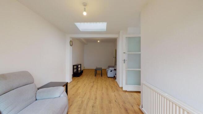 Bright and spacious living room with a skylight...