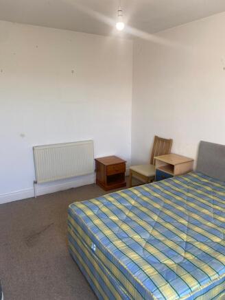 Simple furnished bedroom with a double bed, neu...