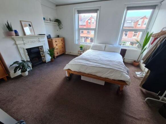 A spacious and well-lit master bedroom featurin...