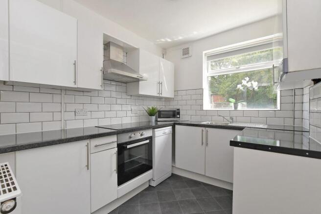 Bright, modern kitchen with glossy white cabine...