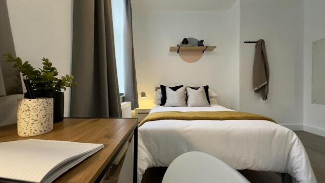 A stylish and well-lit double bedroom featuring...