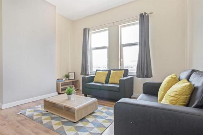 Bright, modern living room with matching sofas,...