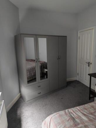 Modern bedroom with large mirrored wardrobe...