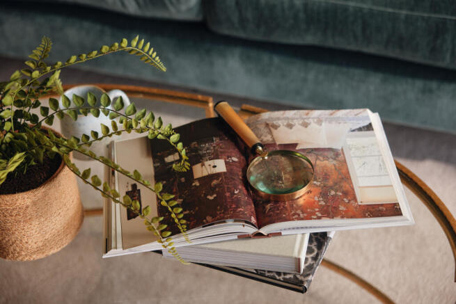 Books and magnifying glass on coffee table in living room