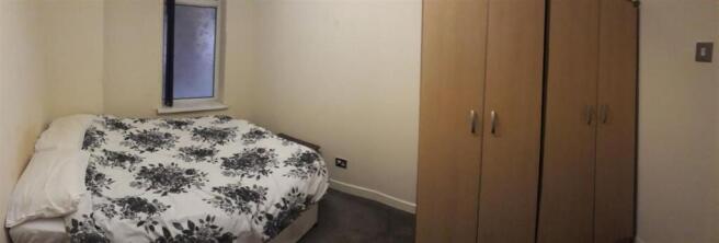 Cozy double bedroom with a patterned duvet, bui...
