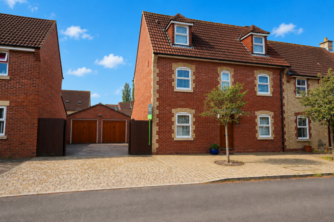 Front with double garage and gated drivway to the