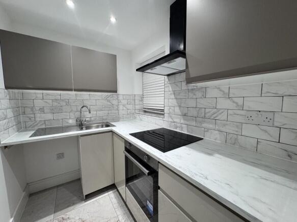 Modern compact kitchen with sleek grey cabinetr...