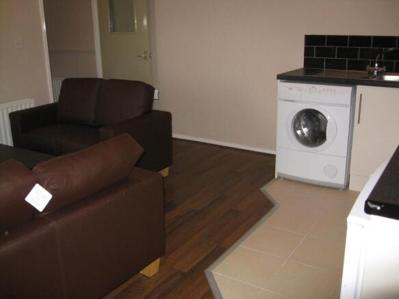 Open-plan living area with brown leather sofas,...