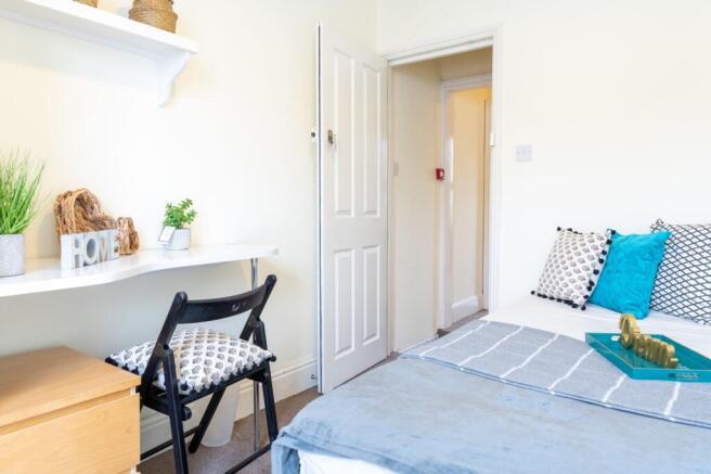 Bright, neatly styled bedroom with a comfortabl...