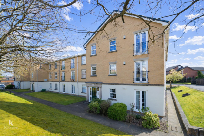 Sunny apartment building with green lawn.png
