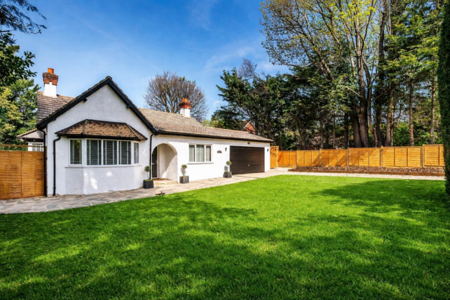 Charming white bungalow on lush lawn.png