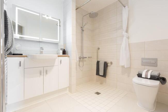 a bathroom with a shower unit and toilet