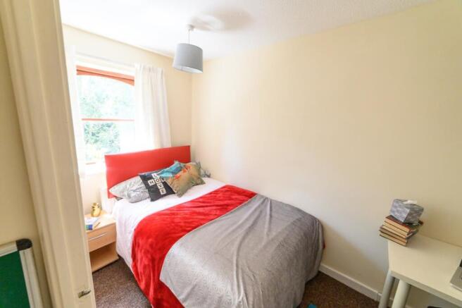Bright, neatly presented bedroom with a padded ...
