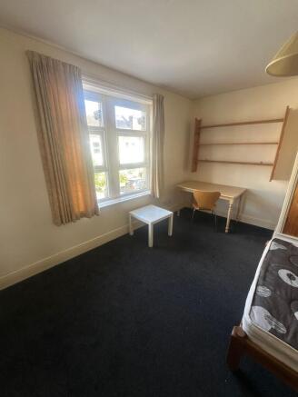 Bright bedroom with desk and ample shelving...