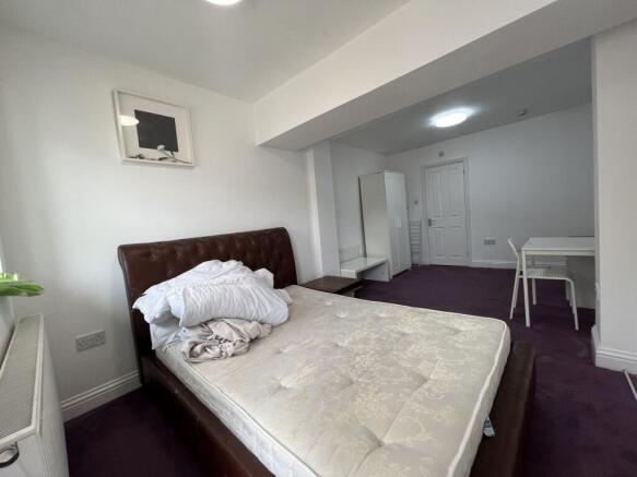 Bright, newly painted bedroom with a large leat...