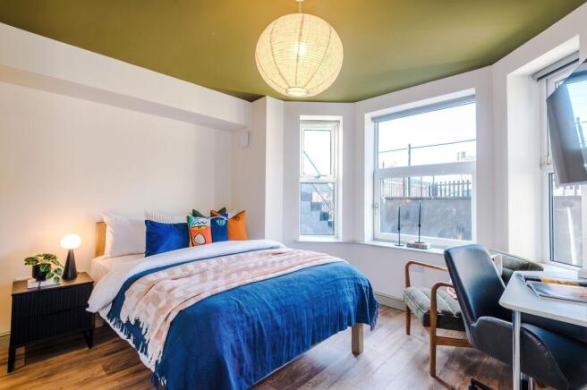 Bright, stylish bedroom with a comfortable doub...