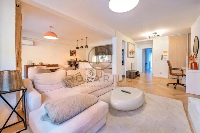 A modern, open-concept living room with cozy white