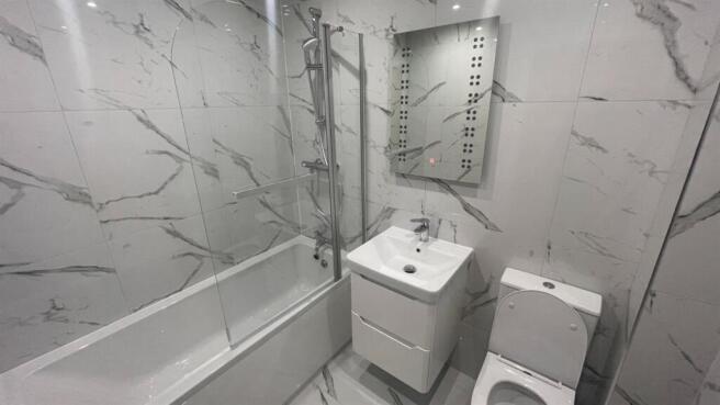 Contemporary bathroom with marble-effect wall t...