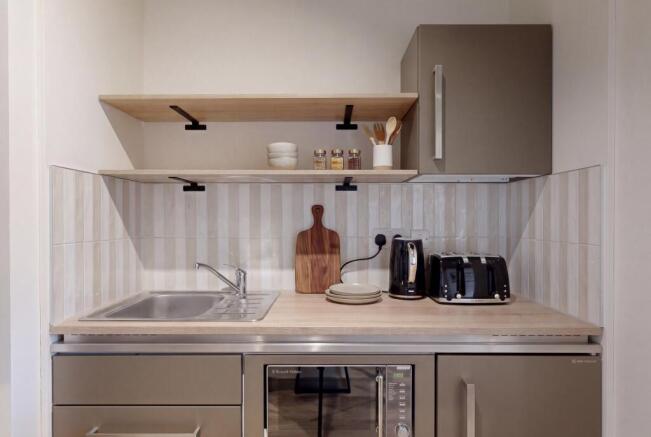 Modern kitchenette with sleek integrated applia...