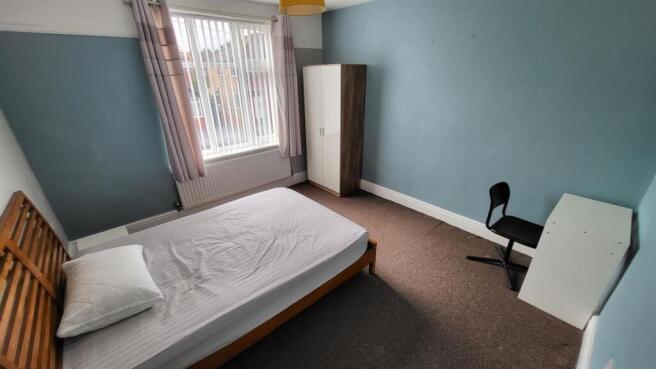 A tidy and well-lit single bedroom featuring a ...