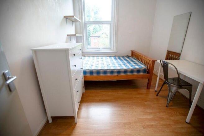 Bright bedroom with bed, desk and storage...