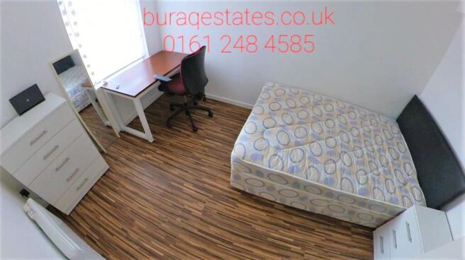 Neat, simply furnished bedroom with a comfortab...