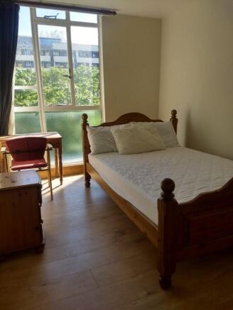 Bright bedroom with large window and study desk...