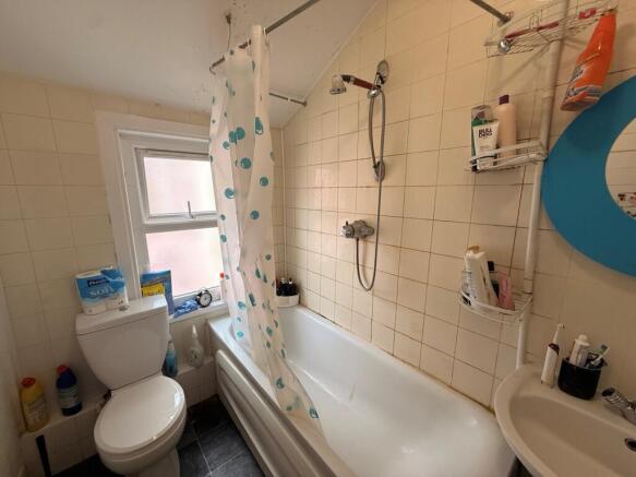 Compact bathroom with a shower-over-bath, patte...