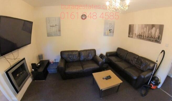 Cozy living room with two leather sofas, wall-m...