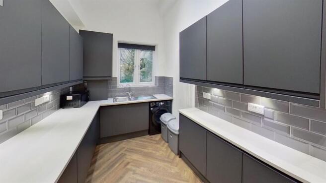 Modern kitchen with sleek cabinetry and window...
